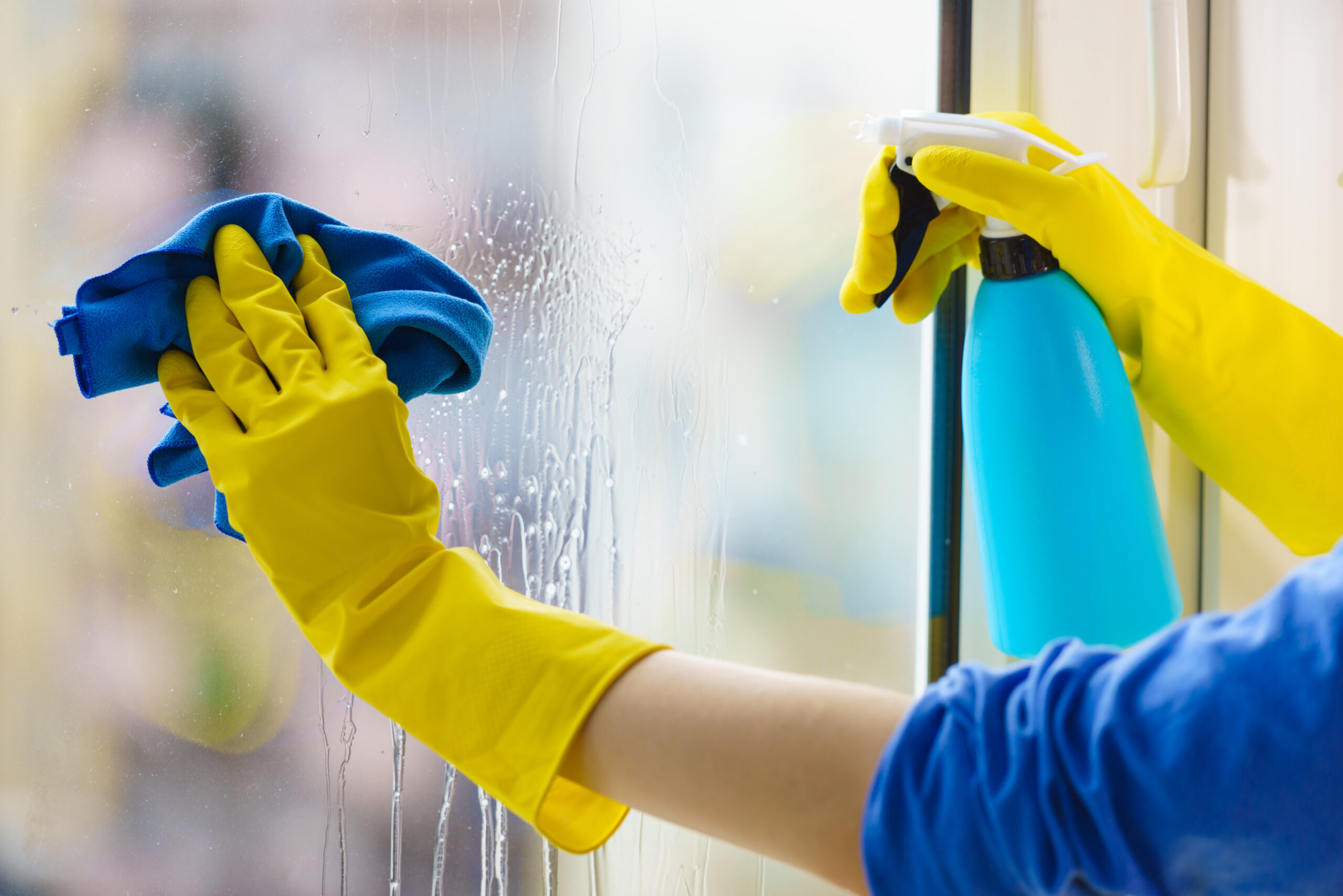 Image a hand cleaning a window with a cloth